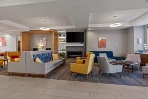uma sala de estar com sofás e cadeiras e uma lareira em Holiday Inn Express Hotel & Suites Oklahoma City Northwest, an IHG Hotel em Oklahoma City