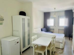 a bedroom with a bed and a table and a table and chairs at Netanya Sea Studio in Netanya