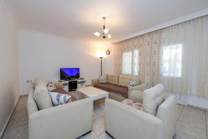 ein Wohnzimmer mit zwei Sofas und einem Fernseher in der Unterkunft Kavak Garden in Fethiye