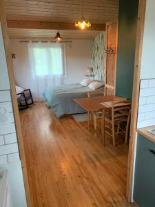 a bedroom with a bed and a table in a room at Chalet de la Baume in La Châtelaine
