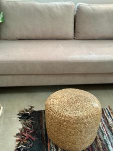 a living room with a couch and a wicker stool at Hotel Imperial in Dhërmi