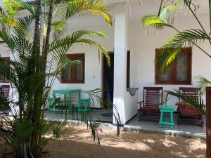 um pátio com mesas e cadeiras e uma palmeira em Moxy Bay Arugambay em Baía de Arugam