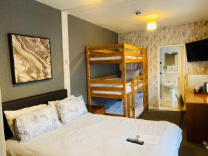 ein Schlafzimmer mit einem Bett und einem Etagenbett in der Unterkunft Bromptons in Blackpool