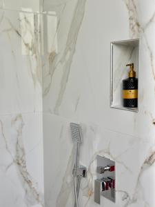 a white bathroom with a shower and a sink at Hotel Imperial in Dhërmi