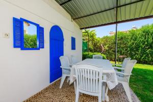 ein Tisch und Stühle auf einer Terrasse mit einer blauen Tür in der Unterkunft Kavak Garden in Fethiye