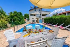 ein Tisch mit Essen und Stühlen neben einem Pool in der Unterkunft Kavak Garden in Fethiye