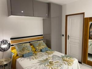 - une chambre avec un lit doté d'oreillers jaunes et bleus dans l'établissement PreciousHome, à Pointe-à-Pitre