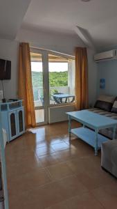 a living room with a bed and a table and a balcony at Guest House Chalakov in Sinemorets