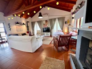 een woonkamer met een witte bank en een open haard bij La Hacienda Apartments Belgrade in Draževac