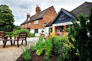 a inn with two chairs and a bench in front of it at The Moat Wrotham in Wrotham