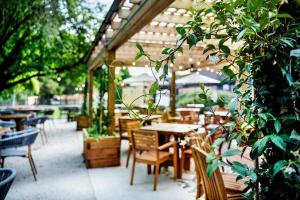 an outdoor restaurant with tables and chairs and a tree at The Moat Wrotham in Wrotham