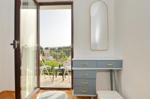 a dressing table and mirror in a room with a balcony at Sorelle Apartment in Tivat