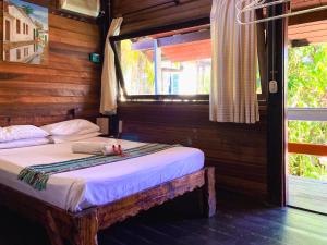 a bedroom with a bed in a room with a window at Hostel Sereia do Mar in Paraty
