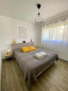 una camera da letto con un grande letto con un cuscino giallo di La petite maison a Robion en Luberon