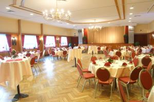 un salón de banquetes con mesas y sillas blancas en Röhrs Gasthof, en Sottrum