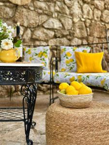 a table with a bowl of lemons and a bottle of wine at Hotel Imperial in Dhërmi