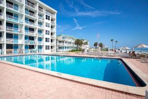 una piscina frente a un gran edificio de apartamentos en SeaBliss, oceanfront 1st floor cozy condo, en Daytona Beach