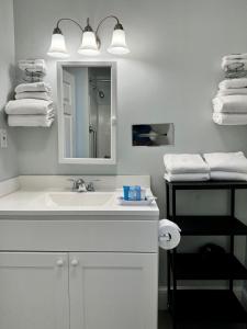ein Badezimmer mit einem Waschbecken, einem Spiegel und Handtüchern in der Unterkunft The Even'tide in Wellfleet