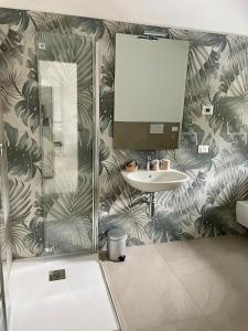 ein Bad mit einem Waschbecken und einem Spiegel in der Unterkunft Hotel Giardino in Breno