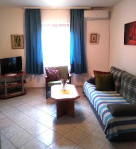 sala de estar con sofá y mesa en Ivago Apartments, en Privlaka
