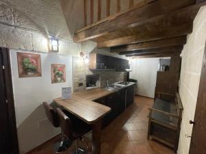 eine Küche mit einem Holztisch und einem Waschbecken in der Unterkunft Xenia renting in Massafra