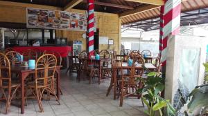 a restaurant with wooden tables and chairs and a counter at Betesda Guest House in Canggu