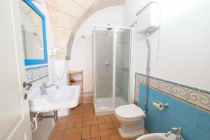 a bathroom with a shower and a toilet and a sink at Masseria Borgo Santuri in Ostuni