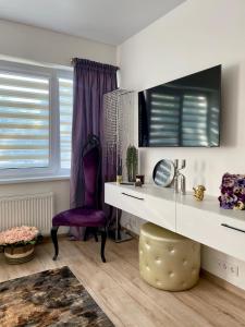 Habitación con escritorio y silla morada. en Stilingi Apartamentai SELF CHECK-IN & Free Parking, en Klaipėda