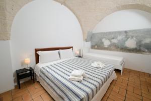 a bedroom with a bed with towels on it at Masseria Borgo Santuri in Ostuni