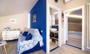 Una habitación con una pared de acento azul y un dormitorio en MONTEROSSO GARDEN House PLUS, en Monterosso al Mare