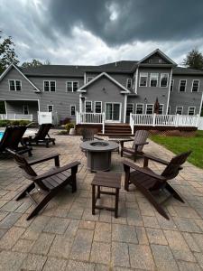 un patio con panche e tavoli di fronte a un edificio di 9 Bedroom Saratoga Home, In-Ground Heated Pool, HotTub, Firepit, BBQ, Gourmet Kitchen, Fireplace a Saratoga Springs
