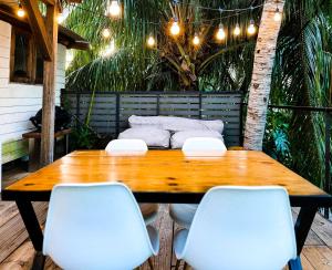 drewniany stół i 2 białe krzesła na patio w obiekcie Ti Bout Paradi Ti Zil w mieście Tamarin