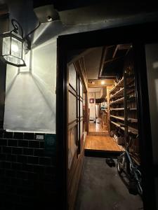 una porta aperta per una camera con muro di mattoni di Hostel Otro Mundo a Kyoto
