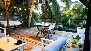 um pátio com uma mesa, cadeiras e palmeiras em Ti Bout Paradi Ti Zil em Tamarin