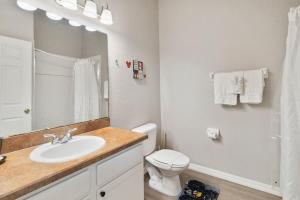 a bathroom with a sink and a toilet and a mirror at Beautiful condo in Bahama Bay in Kissimmee +22 photos