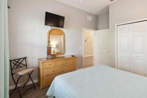 a bedroom with a bed and a mirror and a dresser at Beautiful condo in Bahama Bay in Kissimmee