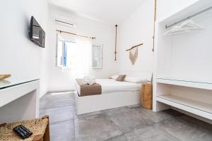 Dieses weiße Zimmer verfügt über ein Bett und einen TV. in der Unterkunft Salento Boutique Room B&B in Sant'Isidoro