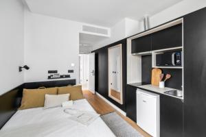 małą sypialnię z łóżkiem i kuchnią w obiekcie Home and CoLiving Pamplona w Pampelunie