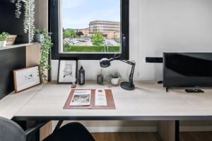 escritorio con libro, lámpara y ventana en Home and CoLiving Pamplona en Pamplona