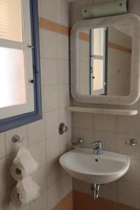 a bathroom with a sink and a mirror at Panormos Apartments in Panormos +45 photos