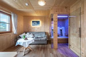 - un salon avec un canapé et un lit dans l'établissement Luxury and Nature House Moarlhof, à Castelrotto