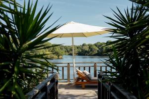 an umbrella sitting on a deck next to a body of water at Vale do Gaio Hotel in Torrão