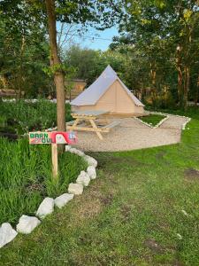 a tent in a field with a sign in the grass at Glamping at Camp Corve in Chale