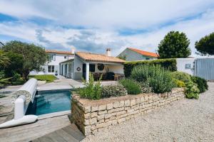 een huis met een zwembad en een huis bij Villa Cote Ouest in La Flotte
