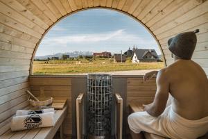 um homem sentado numa sauna a olhar pela janela em Zaciszne Domki w Kluszkowcach z Sauną i Balią em Kluszkowce