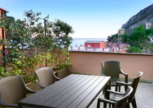Una mesa y sillas en un balcón con vista al mar. en MONTEROSSO GARDEN House PLUS, en Monterosso al Mare