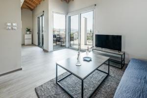 a living room with a table and a tv at Avras experience in Faraí