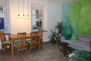 a living room with a table and chairs and a couch at Pasithea Zittau in Zittau