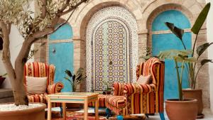 a living room with two chairs and a table at Riad Al Manara in Essaouira