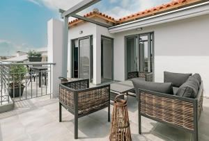 a patio with a couch and chairs on a balcony at Avras experience in Faraí